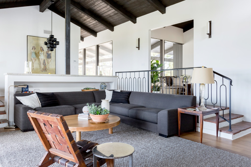 Modelo de salón retro con paredes blancas, suelo de madera en tonos medios y suelo marrón