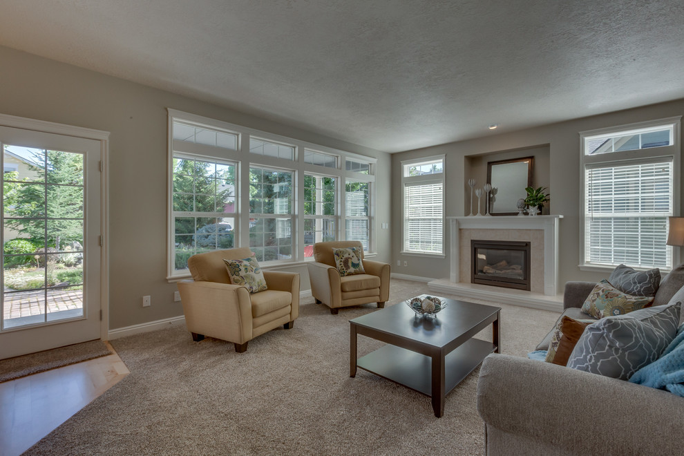 Large classic open plan living room in Boise with grey walls, carpet, a standard fireplace and a tiled fireplace surround.