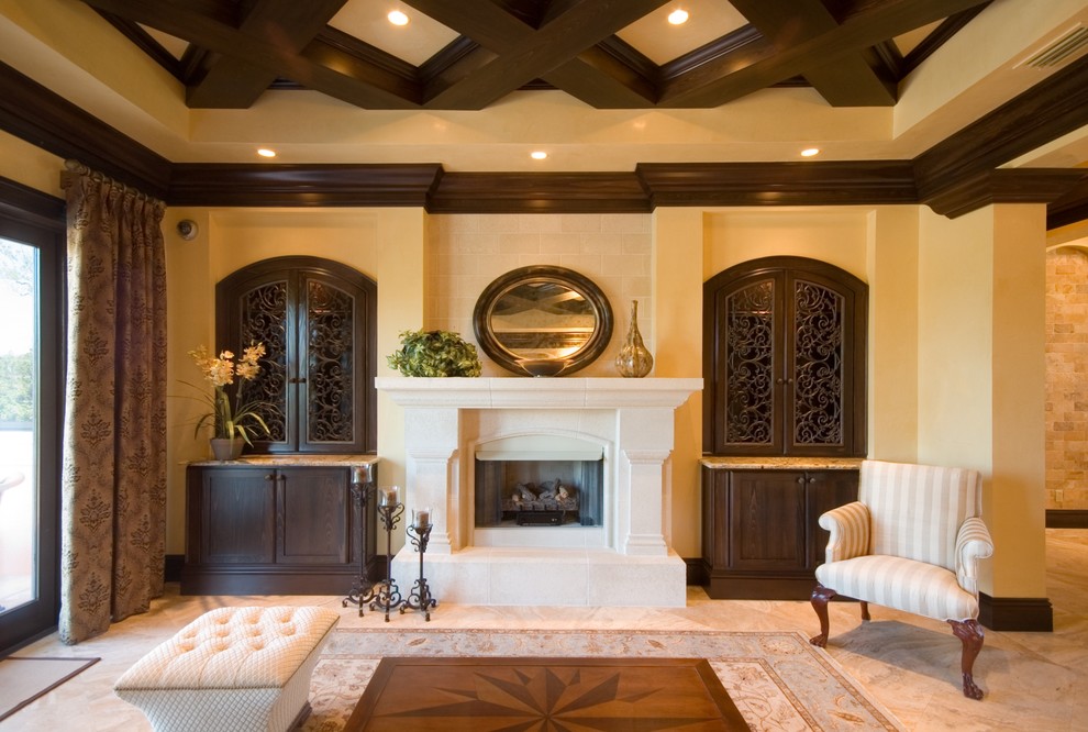 На фото: гостиная комната в средиземноморском стиле с желтыми стенами, стандартным камином и красивыми шторами без телевизора с