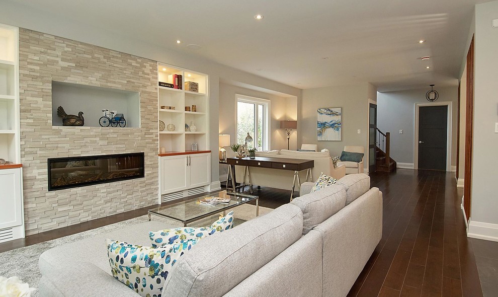 Example of a mid-sized trendy formal and open concept medium tone wood floor and brown floor living room design in Toronto with beige walls, a standard fireplace, a metal fireplace and no tv