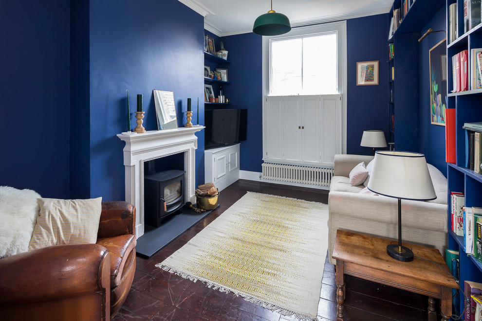 Großes, Repräsentatives, Offenes Klassisches Wohnzimmer mit blauer Wandfarbe, dunklem Holzboden, Kaminofen, verputzter Kaminumrandung, TV-Wand und braunem Boden in London