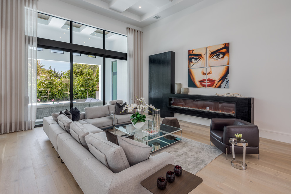 Repräsentatives, Fernseherloses Modernes Wohnzimmer mit weißer Wandfarbe, hellem Holzboden, Gaskamin und beigem Boden in Miami