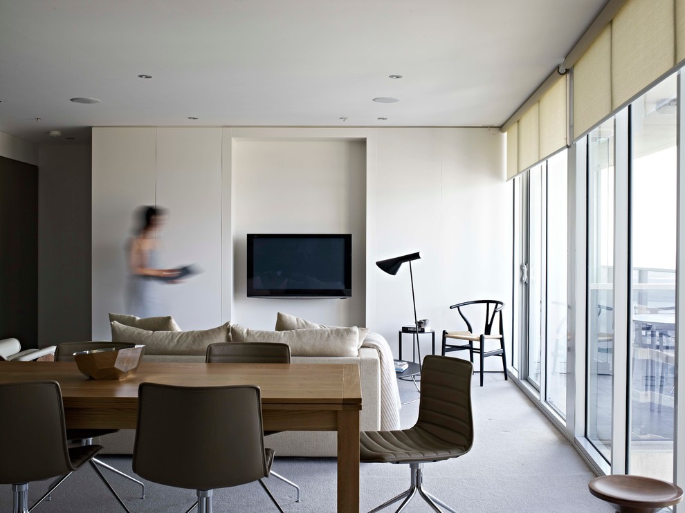 Ejemplo de salón abierto contemporáneo con paredes blancas y televisor colgado en la pared
