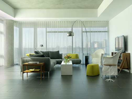 Modelo de salón abierto moderno con paredes blancas, suelo de baldosas de porcelana y televisor colgado en la pared