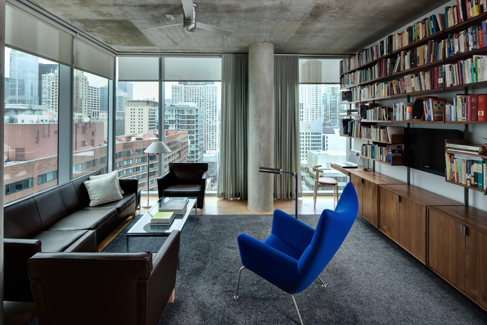 Inspiration för ett industriellt vardagsrum, med ett bibliotek och grå väggar