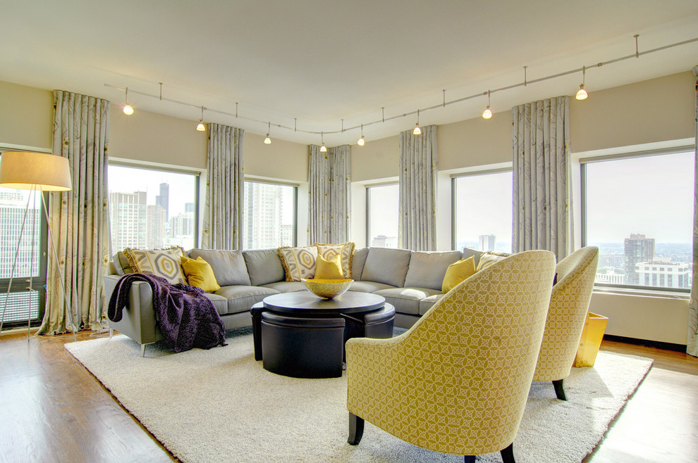 Источник вдохновения для домашнего уюта: большая открытая гостиная комната:: освещение в современном стиле с желтыми стенами, светлым паркетным полом и телевизором на стене