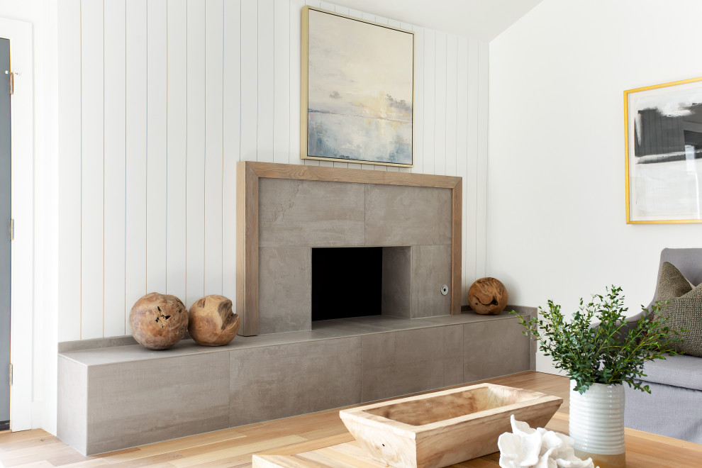 ダラスにあるラグジュアリーな広いビーチスタイルのおしゃれなLDK (白い壁、淡色無垢フローリング、標準型暖炉、タイルの暖炉まわり、茶色い床) の写真