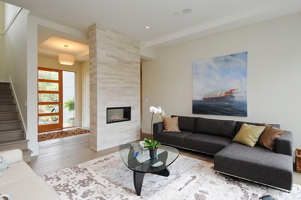 Стильный дизайн: гостиная комната в стиле модернизм с бежевыми стенами и двусторонним камином - последний тренд