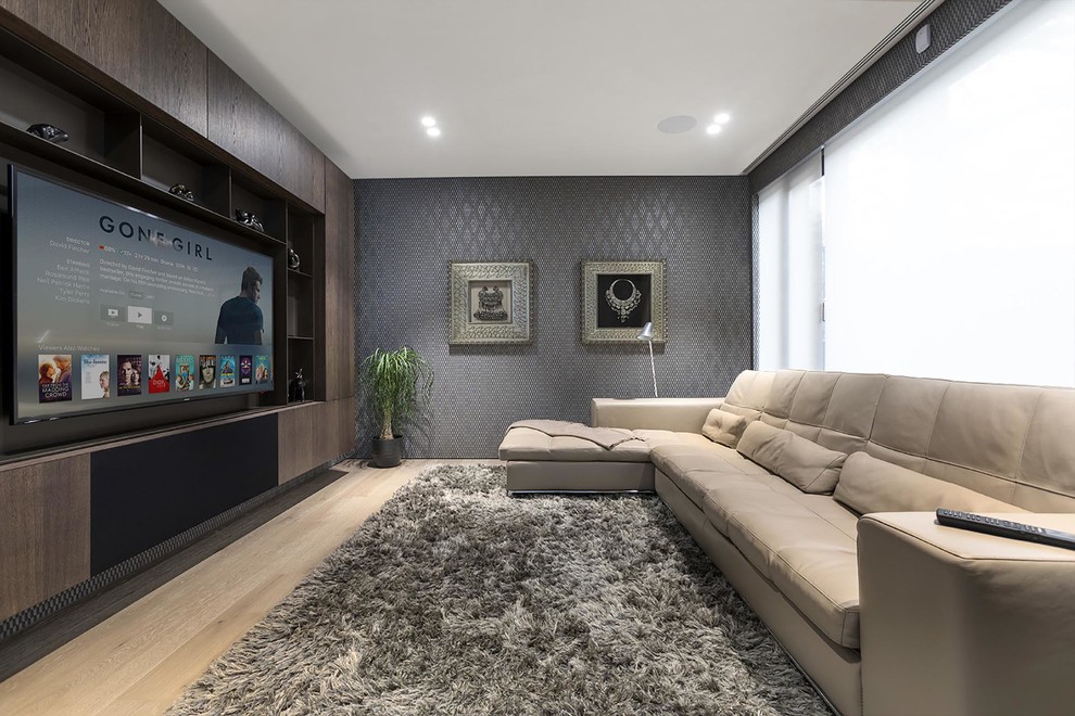 Idée de décoration pour un salon minimaliste de taille moyenne et fermé avec un mur gris, parquet clair, un téléviseur encastré et un sol beige.