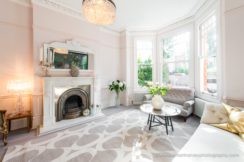 Design ideas for a large contemporary enclosed living room in London with pink walls, a standard fireplace, a stone fireplace surround and no tv.