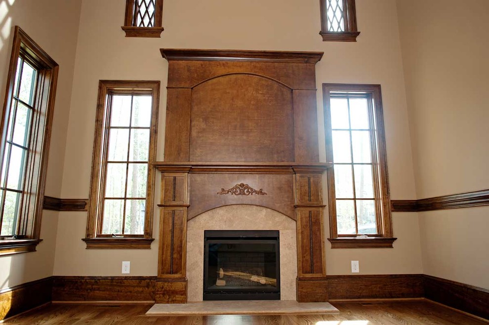 Foto di un soggiorno tradizionale con sala formale, pareti beige, pavimento in legno massello medio, camino classico e cornice del camino in legno