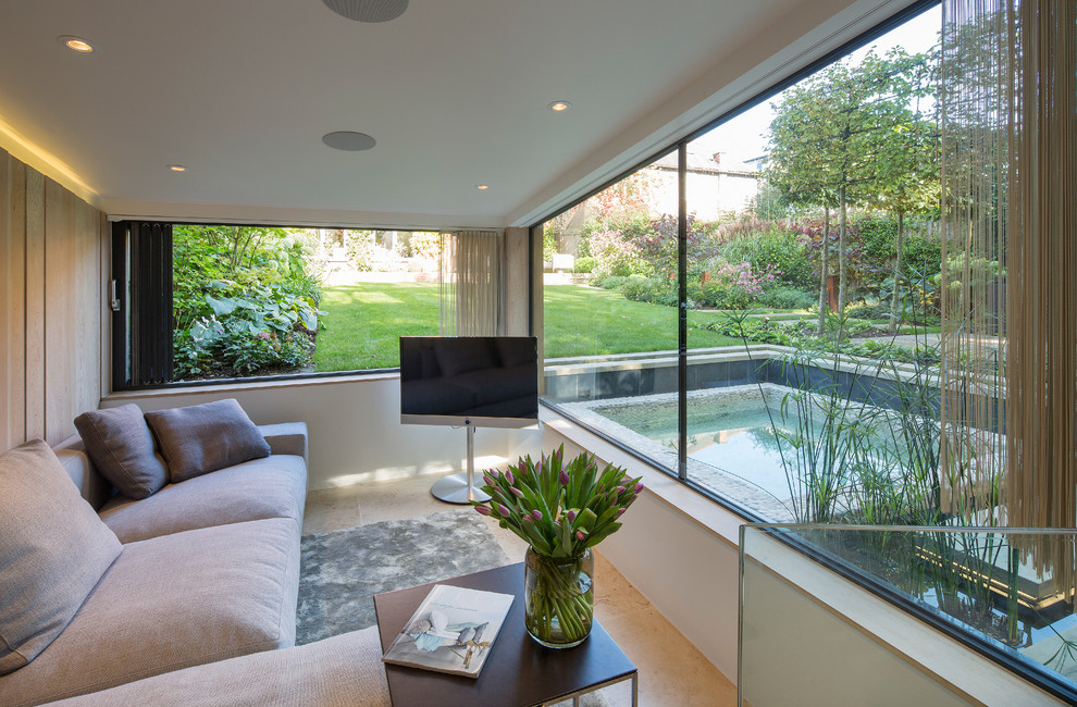 Modernes Wohnzimmer mit beiger Wandfarbe und freistehendem TV in London
