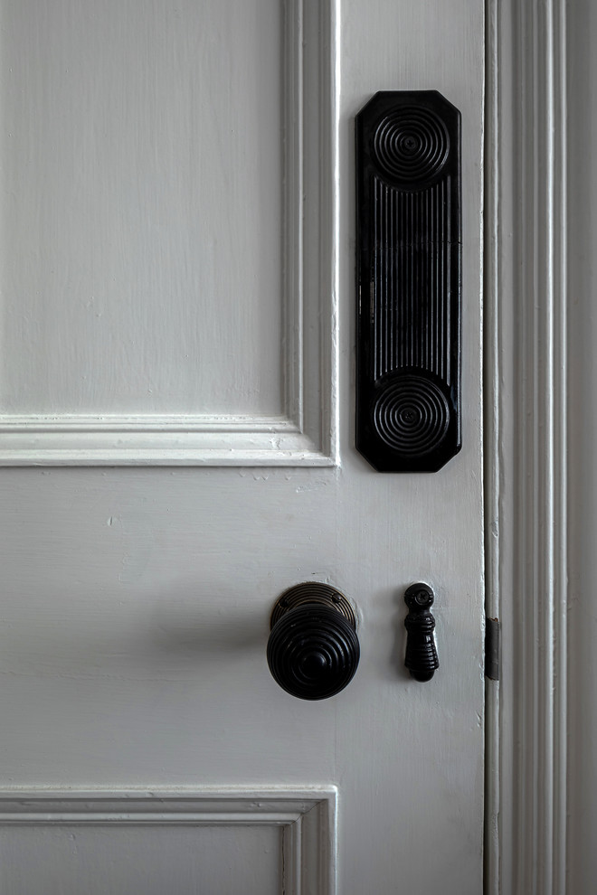 Mittelgroßes, Abgetrenntes Klassisches Wohnzimmer mit Hausbar, grauer Wandfarbe, braunem Holzboden, Kamin und gefliester Kaminumrandung in London