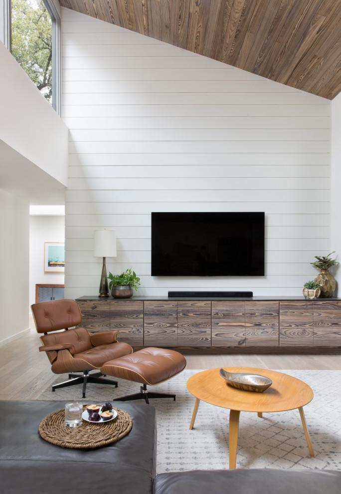 Diseño de salón para visitas abierto campestre sin chimenea con paredes blancas, suelo de madera clara, televisor colgado en la pared y suelo beige