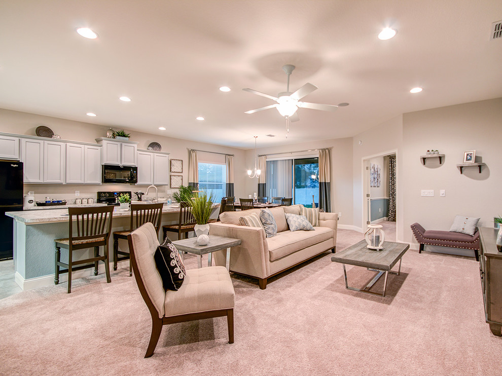 This is an example of a large modern open plan living room in Tampa with beige walls, carpet, no fireplace and beige floors.