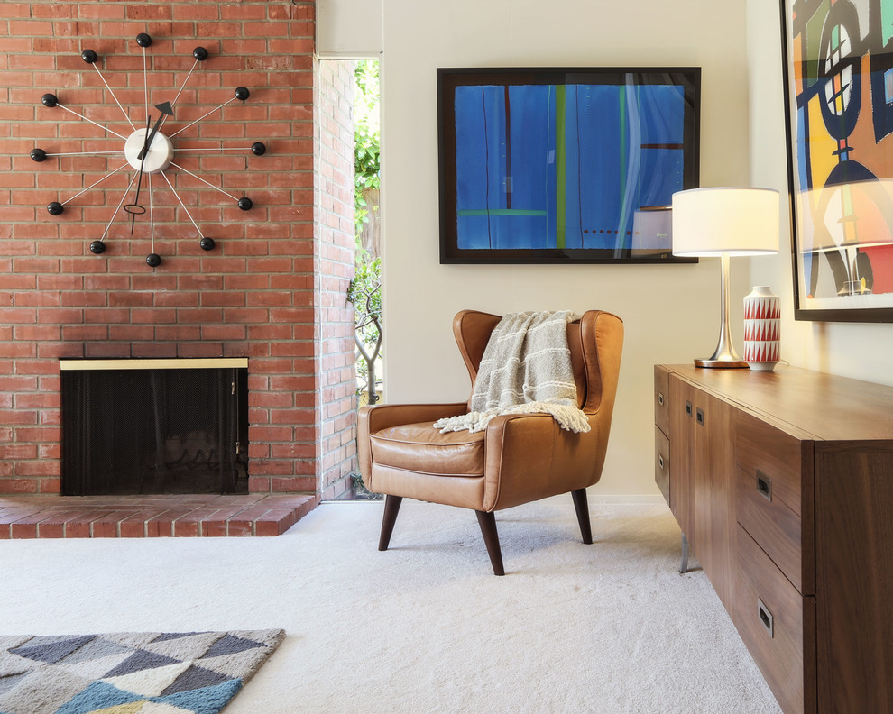 Стильный дизайн: парадная, открытая гостиная комната среднего размера в стиле ретро с бежевыми стенами, ковровым покрытием, стандартным камином, фасадом камина из кирпича, телевизором на стене и серым полом - последний тренд
