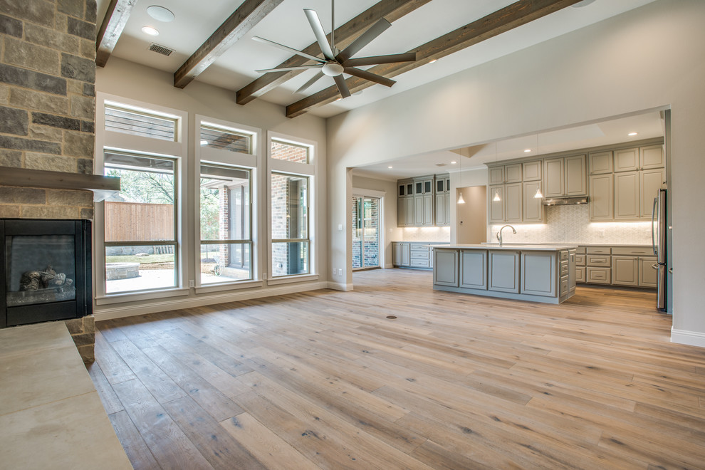 Mittelgroßes, Offenes Klassisches Wohnzimmer mit beiger Wandfarbe, Sperrholzboden, Eckkamin, Kaminumrandung aus Backstein und braunem Boden in Dallas
