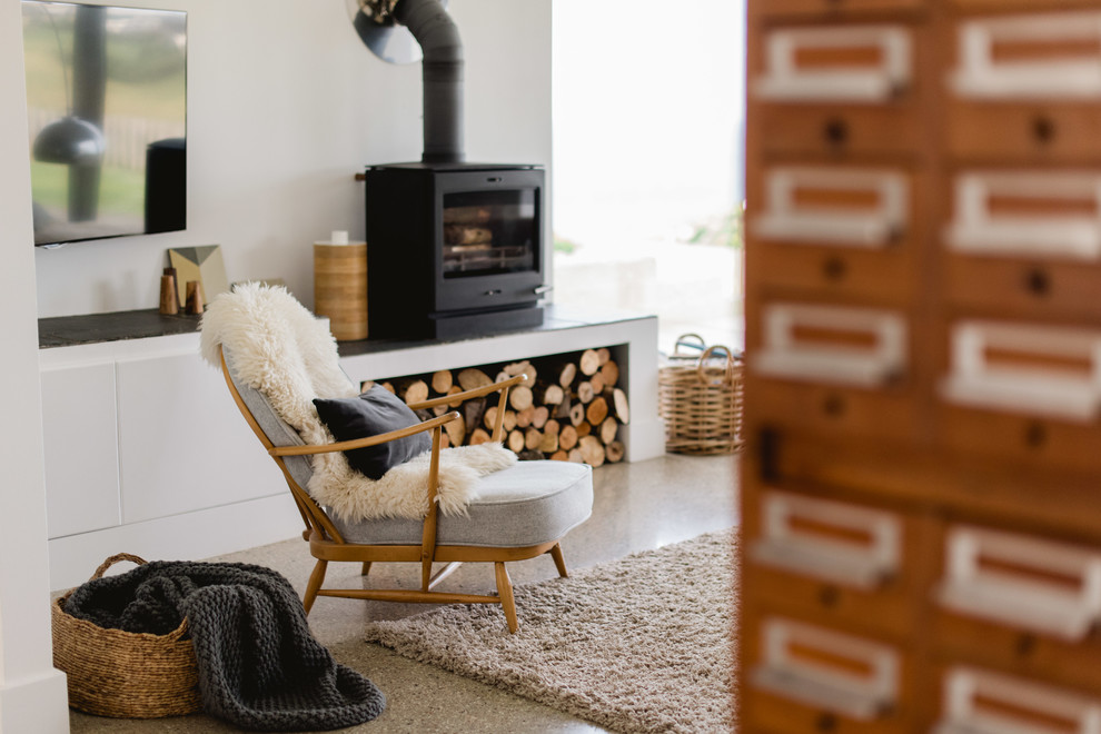 Living room - large contemporary open concept concrete floor living room idea in Other with white walls, a wood stove and a wall-mounted tv