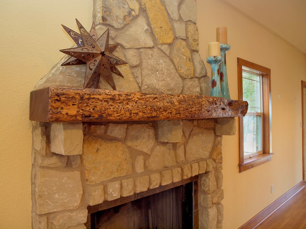 オースティンにある広いトラディショナルスタイルのおしゃれなLDK (ベージュの壁、淡色無垢フローリング、標準型暖炉、石材の暖炉まわり) の写真