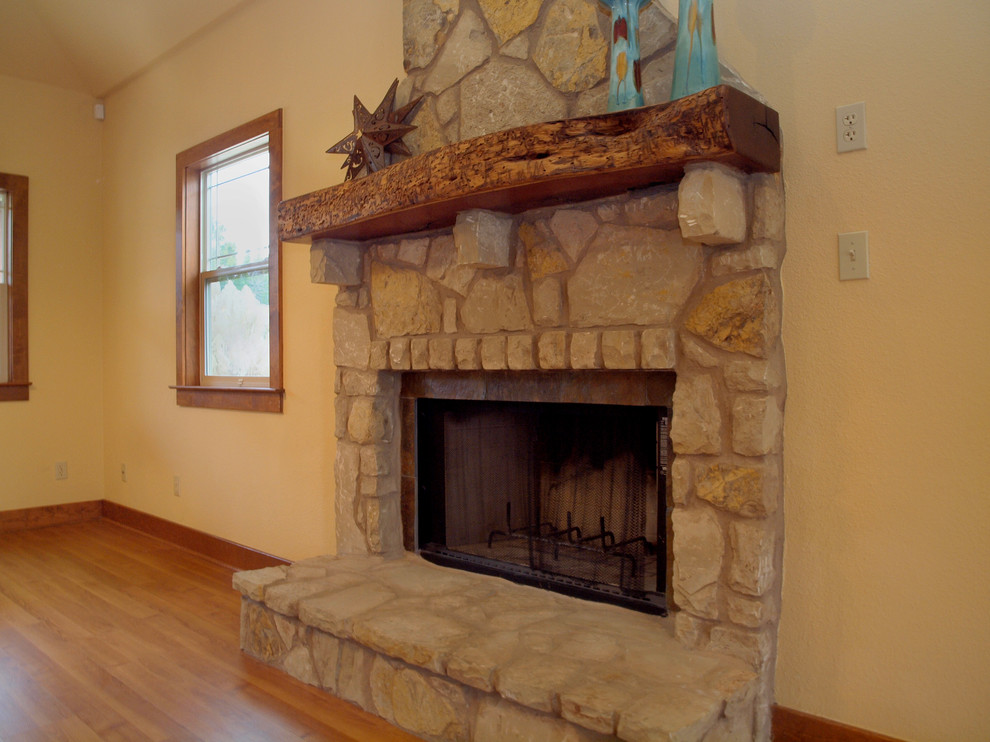 Aménagement d'un grand salon craftsman ouvert avec un mur beige, parquet clair, une cheminée standard et un manteau de cheminée en pierre.