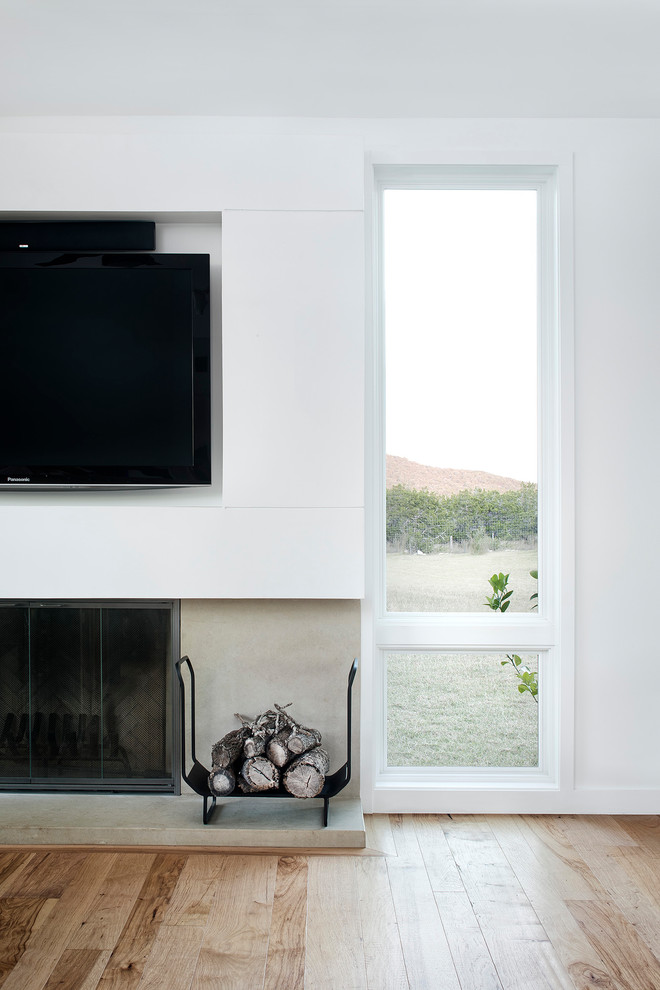 Источник вдохновения для домашнего уюта: открытая гостиная комната среднего размера в современном стиле с белыми стенами, светлым паркетным полом, стандартным камином, фасадом камина из камня и телевизором на стене