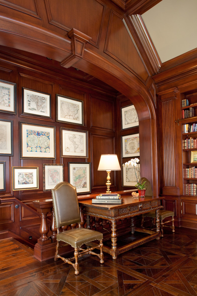 Cette image montre un grand bureau traditionnel avec une bibliothèque ou un coin lecture, parquet foncé, un mur marron et aucune cheminée.