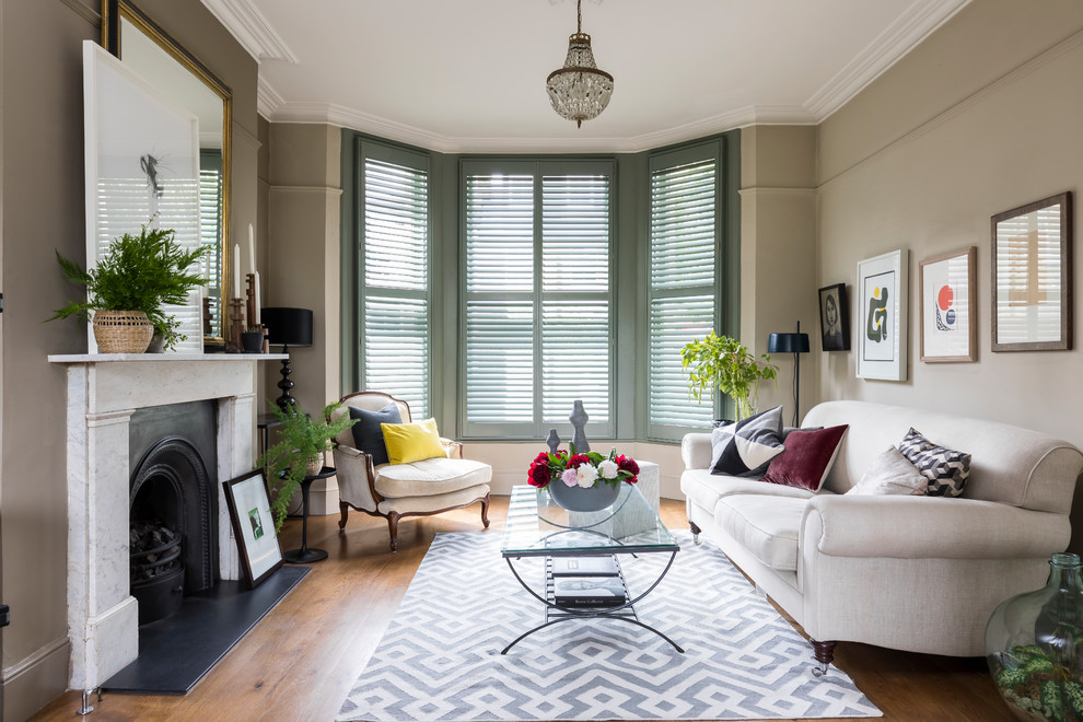 Klassisches Wohnzimmer mit beiger Wandfarbe, braunem Holzboden und braunem Boden in London
