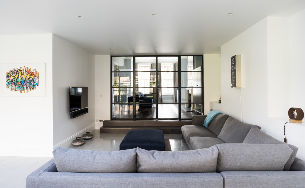 Ispirazione per un ampio soggiorno contemporaneo aperto con pareti bianche, pavimento in cemento, TV a parete e pavimento grigio
