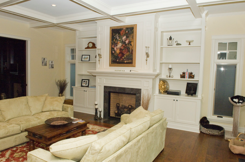 Immagine di un soggiorno tradizionale con sala formale, pareti beige, pavimento in legno massello medio, camino classico e cornice del camino in pietra