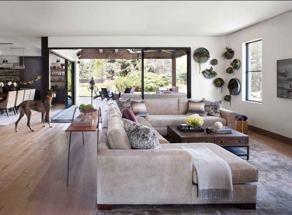 Foto di un grande soggiorno eclettico aperto con pareti bianche, TV a parete, pavimento in legno massello medio e pavimento marrone