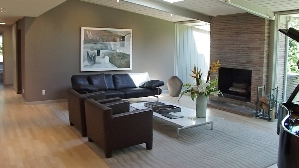 Foto di un soggiorno minimalista di medie dimensioni e aperto con sala formale, pareti beige, parquet chiaro, camino classico, cornice del camino in pietra e nessuna TV