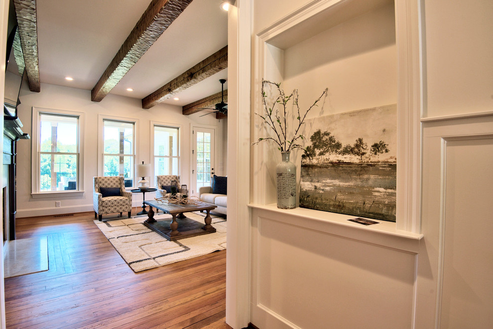 Example of a large farmhouse open concept medium tone wood floor living room design in Raleigh with white walls, a standard fireplace, a stone fireplace and a wall-mounted tv