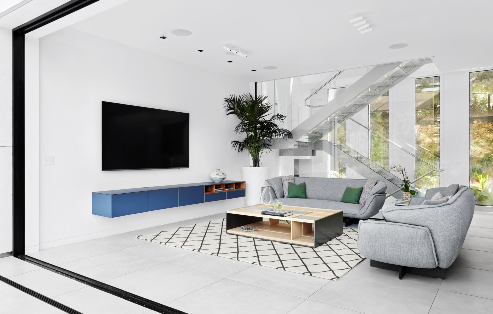 Photo of a large contemporary open plan living room in San Francisco with white walls, ceramic flooring, a wall mounted tv and grey floors.