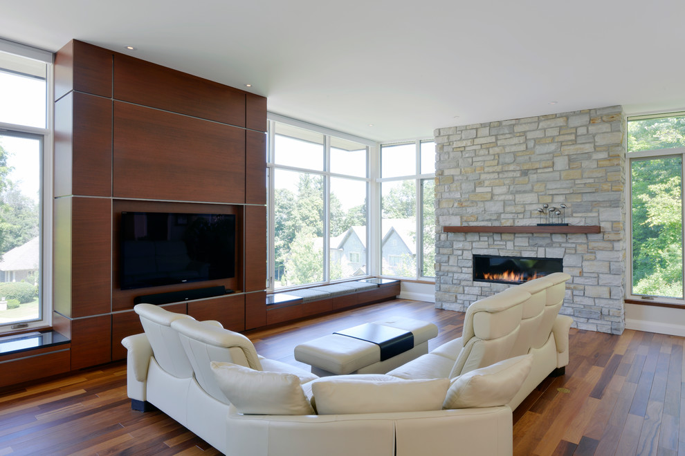 Diseño de salón contemporáneo con chimenea lineal y pared multimedia