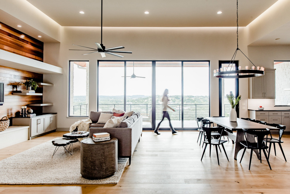 Contemporary open plan living room in Austin with beige walls, medium hardwood flooring and brown floors.