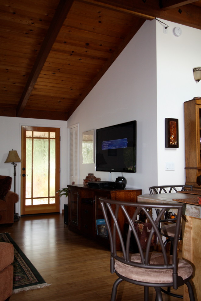 Exempel på ett mellanstort exotiskt allrum med öppen planlösning, med vita väggar, bambugolv, en väggmonterad TV, en standard öppen spis, en spiselkrans i sten och brunt golv