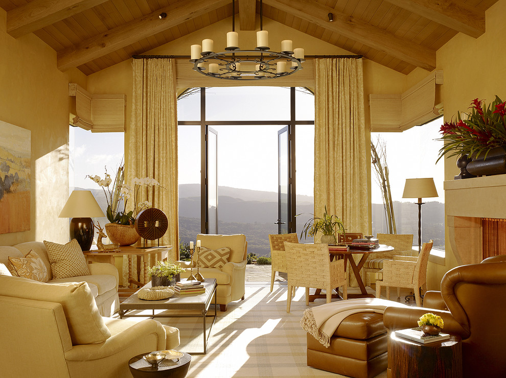 На фото: большая гостиная комната в средиземноморском стиле с стандартным камином и красивыми шторами без телевизора с