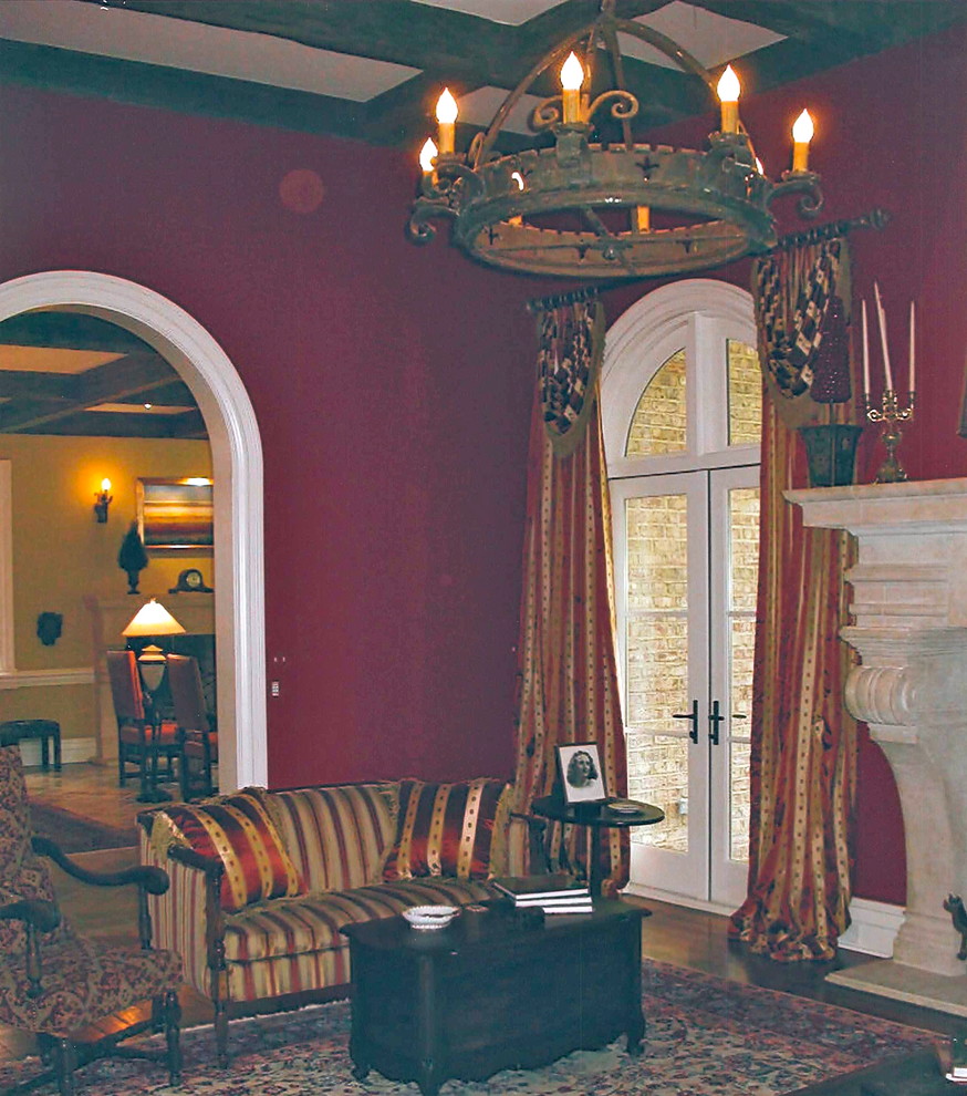 Esempio di un grande soggiorno mediterraneo con sala formale, pareti rosse, pavimento in legno massello medio e cornice del camino in pietra