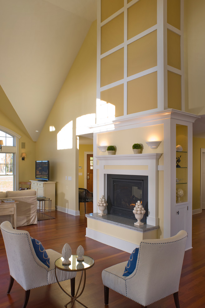 Idée de décoration pour un salon chalet ouvert et de taille moyenne avec une salle de réception, un mur jaune, un sol en bois brun, une cheminée standard, un manteau de cheminée en plâtre et un téléviseur indépendant.