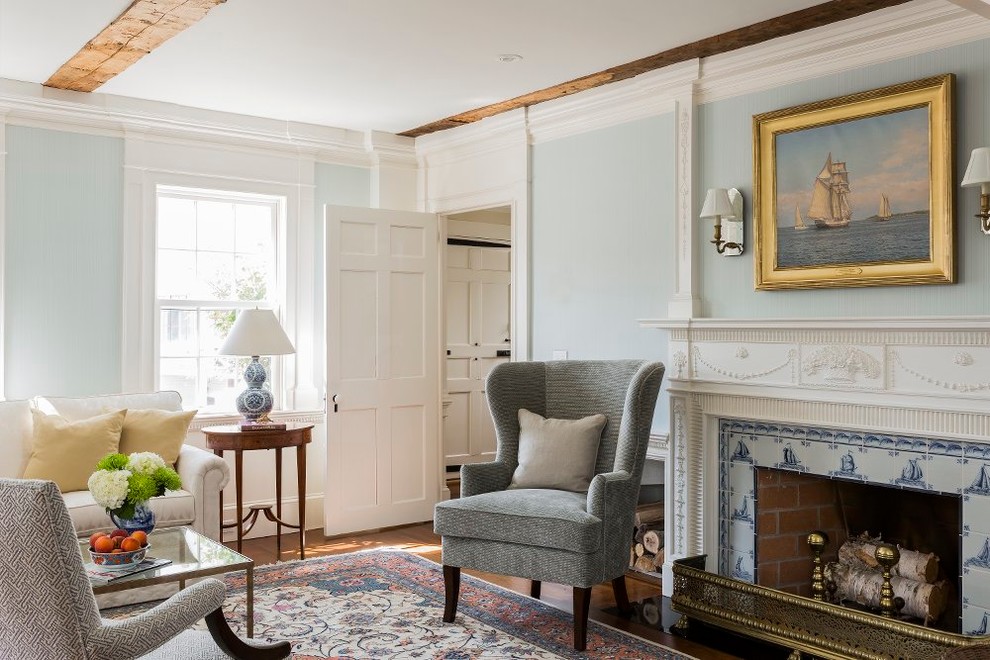 Inspiration pour un salon traditionnel fermé avec une salle de réception, un mur bleu, un sol en bois brun, une cheminée standard et un manteau de cheminée en carrelage.