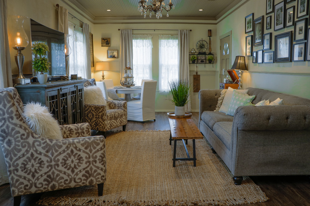 Immagine di un piccolo soggiorno boho chic chiuso con pareti beige, parquet scuro, TV autoportante e pavimento marrone