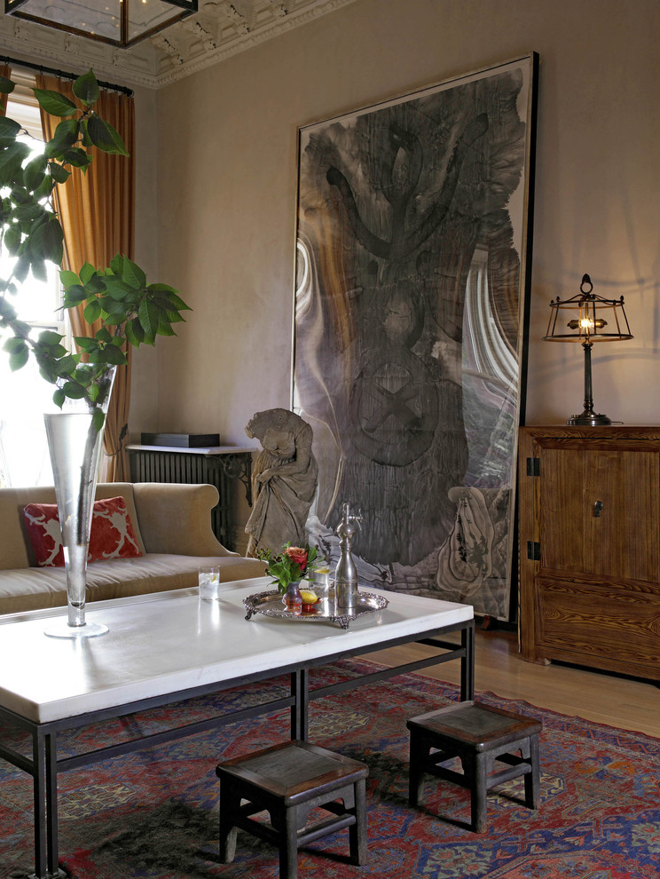 Modelo de salón para visitas abierto moderno grande con paredes beige, suelo de madera en tonos medios, todas las chimeneas, marco de chimenea de piedra y televisor retractable