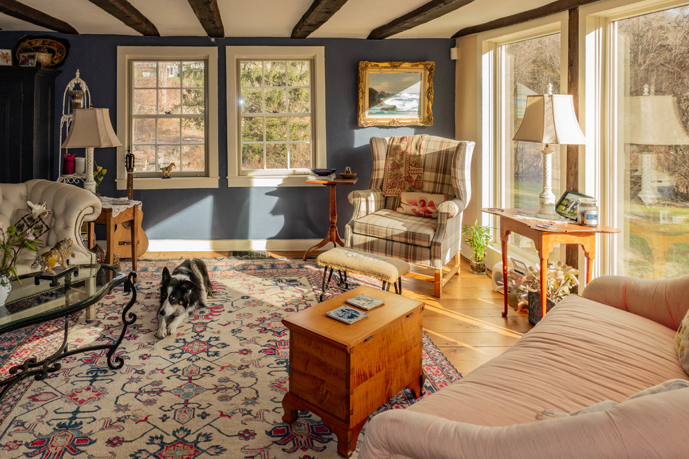 Источник вдохновения для домашнего уюта: гостиная комната в стиле кантри с синими стенами, паркетным полом среднего тона и коричневым полом
