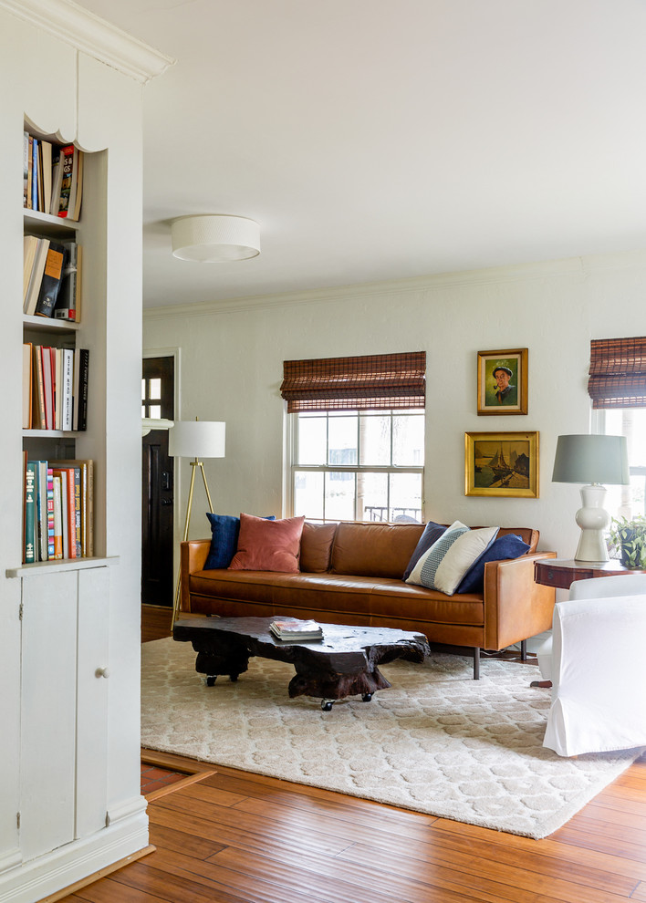 Kleines, Abgetrenntes Stilmix Wohnzimmer mit weißer Wandfarbe, braunem Holzboden, Kamin, Kaminumrandung aus Backstein, TV-Wand und braunem Boden in Dallas