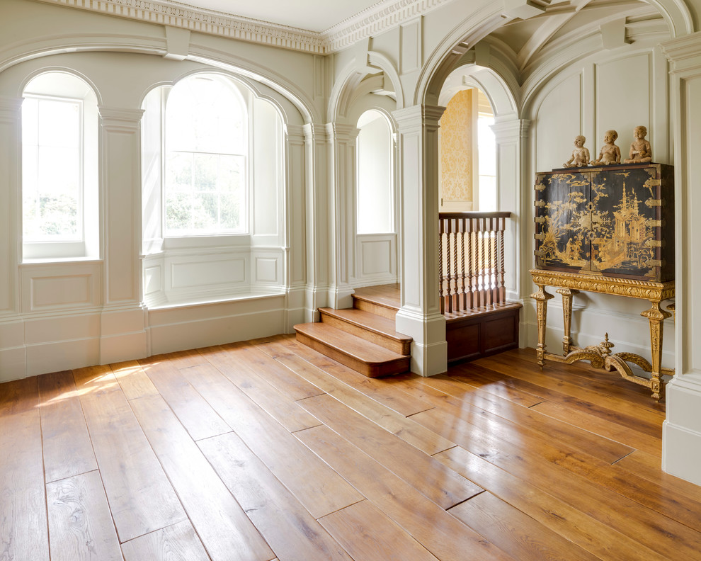 Exemple d'un salon victorien de taille moyenne et fermé avec une salle de réception, un mur blanc, un sol en bois brun, aucune cheminée et un sol marron.