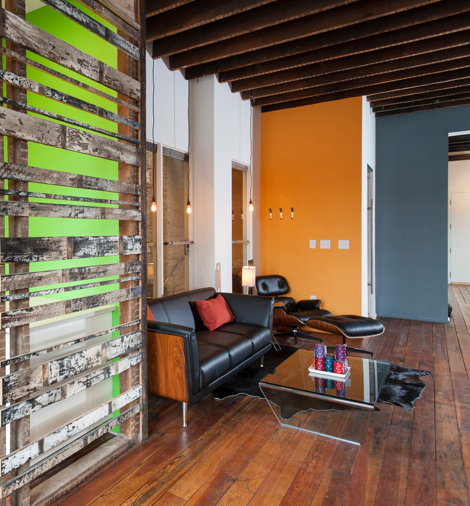 Mittelgroßes, Repräsentatives, Fernseherloses Retro Wohnzimmer im Loft-Stil, ohne Kamin mit braunem Holzboden, oranger Wandfarbe und braunem Boden in Atlanta