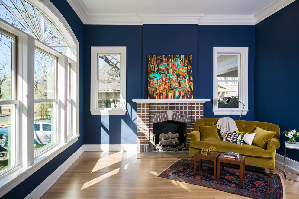 Bild på ett mellanstort funkis vardagsrum, med ett finrum, blå väggar, mellanmörkt trägolv, en standard öppen spis och en spiselkrans i tegelsten