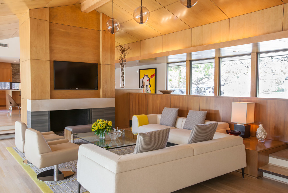 Diseño de salón para visitas abierto retro con suelo de madera clara, todas las chimeneas y televisor colgado en la pared