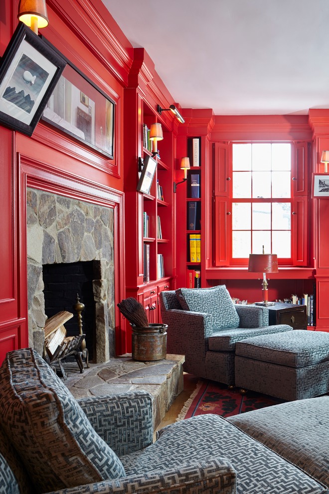 Идея дизайна: большая изолированная гостиная комната в стиле фьюжн с красными стенами, паркетным полом среднего тона, стандартным камином и фасадом камина из камня без телевизора