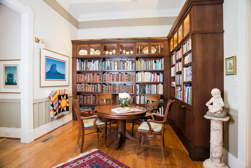 Bild på ett stort vintage separat vardagsrum, med ett bibliotek, vita väggar och mellanmörkt trägolv